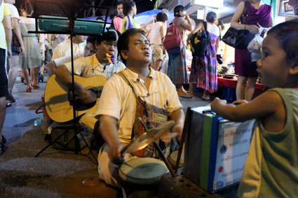 Un grupo de invidentes sentados en plena calle tocan y cantan durante el mercado callejero del Saturday Walking Street, (Chiang Mai).